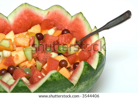 A fresh fruit salad served from a carved watermelon shell.