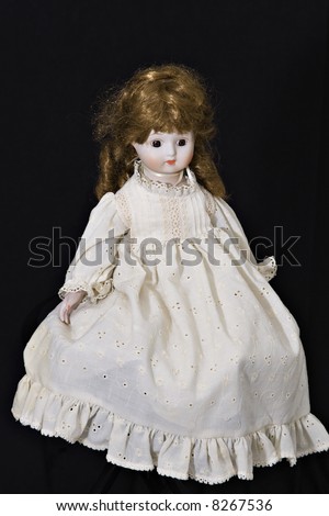 stock photo An old doll dressed in oldfashioned dress on black background 