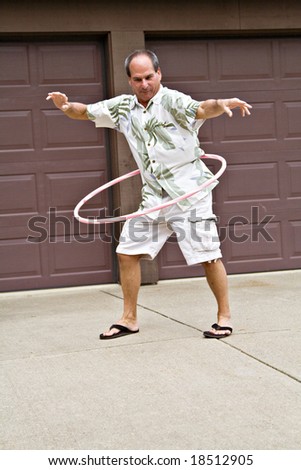 Fifty-five year old man plays with a hula hoop.