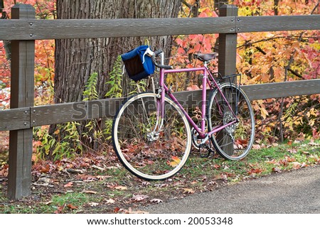 A bike parked along  the bike path in a beautiful park.