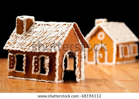 Two gingernut house on wooden table with black islolated background