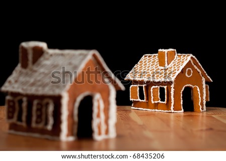 Two gingernut house on wooden table with black islolated background