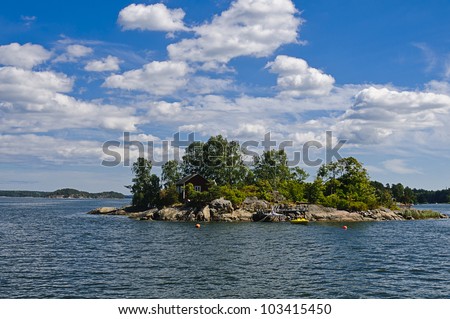 Typical red Swedish cottage on a small rocky island in the Stockholm archipelago, Baltic Sea, Sweden