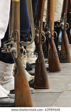 Soldiers in ancient costumes and closeup of boots and rifles