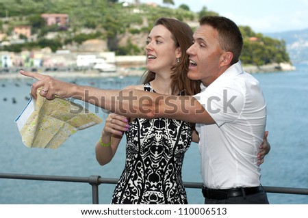 Man and woman tourists with a map on the Mediterranean Sea in Italy