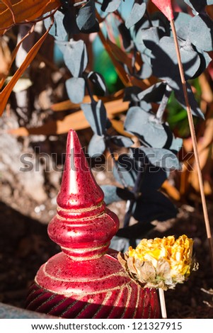 A Christmas ornament sparkles under dried flowers in a pot in Santa Fe, New Mexico