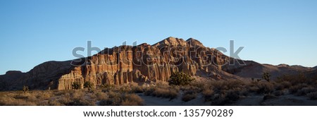 Dawn lights a rock wall at Red Rock Canyon State Park and Red Cliffs Nature Preserve in California\'s Mohave Desert