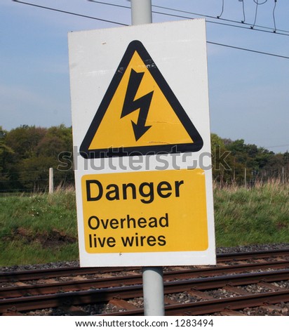 Warning sign on railway lines with wires.