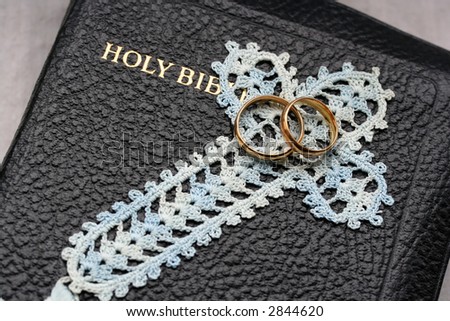 pair of wedding bands on bible with copy space