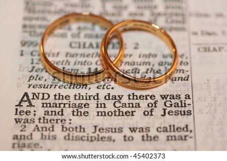 Two gold wedding bands on verse from Bible, macro