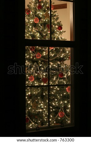 Christmas tree seen through window from outside