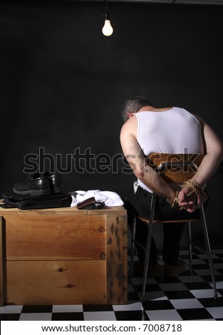 stock photo Businessman with his hands tied up sitting under a bare 