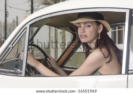 Beautiful woman behind the wheel of a vintage Jaguar car