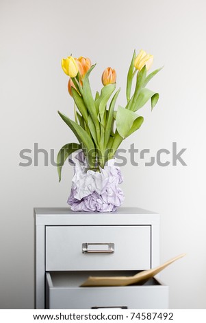 Tulips Flowers in a glass standing on an office board