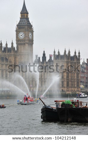 LONDON - JUNE 3rd 2012: A fire boat entertains the crown during Queen Elizabeth Diamond Jubilee River Pageant on June 3rd 2012 in London