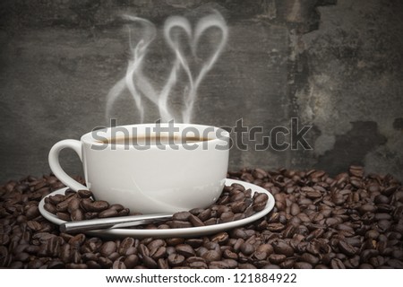 Rustic style setting of hot coffee and coffee beans with heart shape smoke