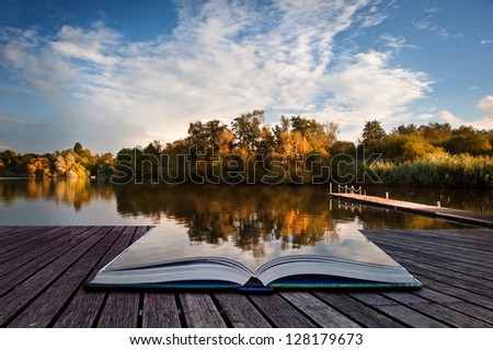 Creative concept image of sunset sky reflected in Autumn Fall lake in pages of book
