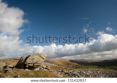Norber Erratics with Moughton Scar and Wharfe Dale in background in Yorkshire Dales National Park