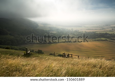 English countryside landscape during late Summer afternoon with dramatic sky and lighting