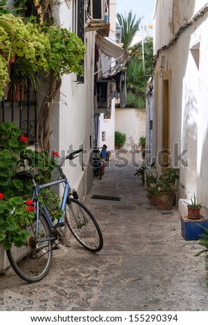 Mediterranean alley way between old houses and buildings with bike and local residents