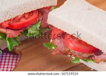Rustic kitchen setting for fresh BLT on white sandwich