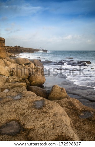 Seascape landscape of waves crashing onto rocks during beautiful Winter\'s day