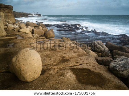 Seascape landscape of waves crashing onto rocks during beautiful Winter\'s day