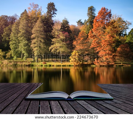 Beautiful Autumn lake landscape with vibrant colors reflected in still waters conceptual book image