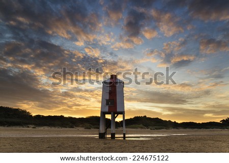Stunning landscape sunrise stilt lighthouse on beach