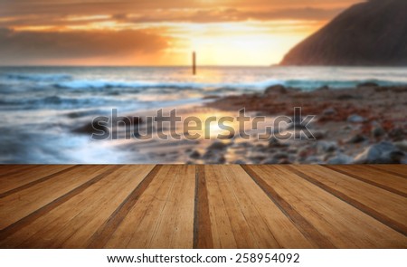 Stunning low tide landscape of beach with sunrise on horizon with wooden planks floor