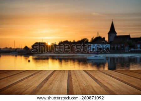 Beautiful Summer sunset landscape over low tide harbor with boats  with wooden planks floor
