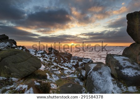 Stunning Winter sunset landscape from mountains looking over countryside