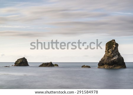 Beautiful long exposure peaceful landscape of rocks in sea