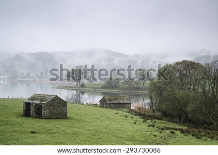 Landscape on foggy morning overlooking fields around Lake Windermere in Lake District