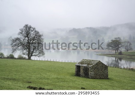 Landscape on foggy morning overlooking fields around Lake Windermere in Lake District