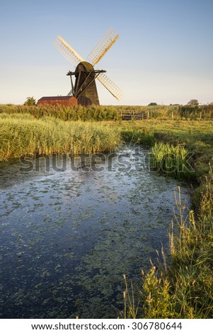 Old drainage pump windmill in English countryside landscape