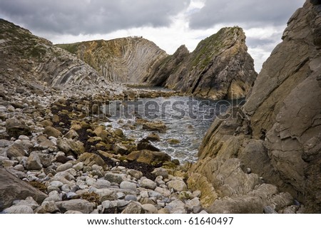Smaller cove on Jurassic Coast in England near Lulworth Cove, very rocky landscape with vibrant blue water