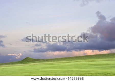 View of golf course with moody sunrise over English landscape