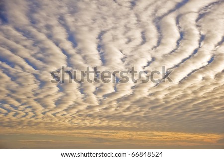 Beautiful fiery glow sunset with fluffy repeating pattern clouds