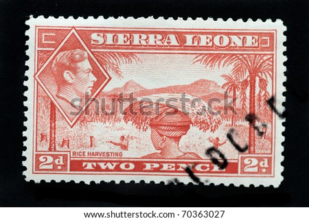 SIERRA LEONE - CIRCA 1940 - Postage stamp showing native of country rice harvesting and inset of King George 6th circa 1940