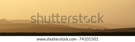 Rolling landscape over hills and valleys on hazy sunny evening