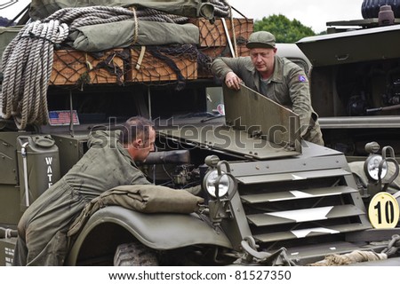 LONDON - JULY 21 - Unidentified members of the public reenact working on a WW2 era military vehicle during War and Peace show, world\'s largest military show, on July 21st, 2011 near London, England
