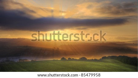 Beautiful golden sunrise glow over fields