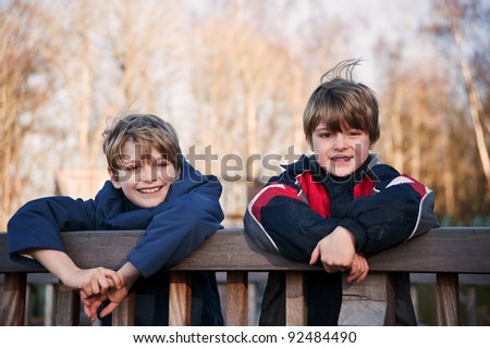 Two young happy handsome brothers playing outdoors in Autumn Fall