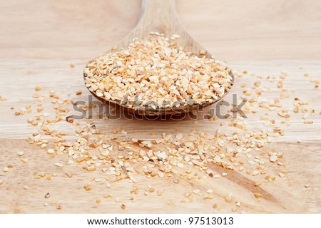 Minced garlic on wooden serving spoon with shallow depth of field