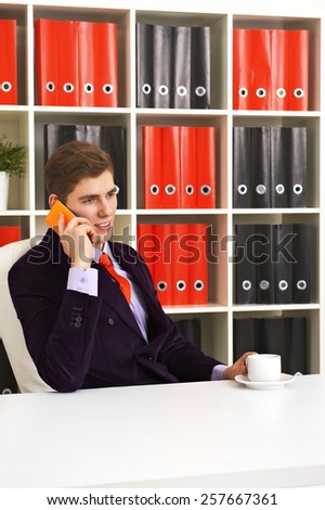 Cheerful Businessman in office answering the phone