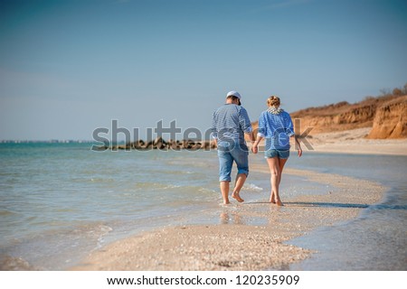 two people walking on the beach