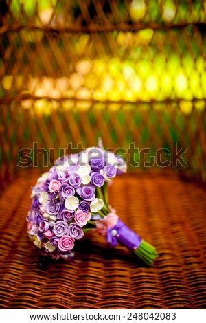 Purple wedding bouquet in a wicker chair