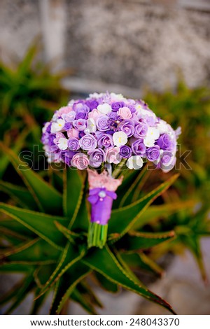 Purple wedding bouquet on the wall of an old building in Montenegro