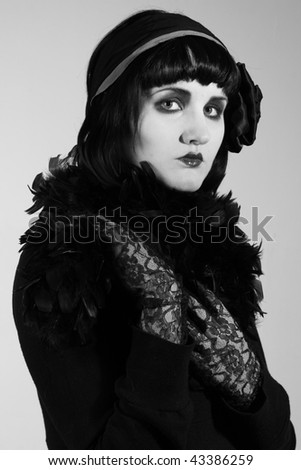 Retro styled black and white fashion portrait of a young woman. Clothing and make-up in twenties style.